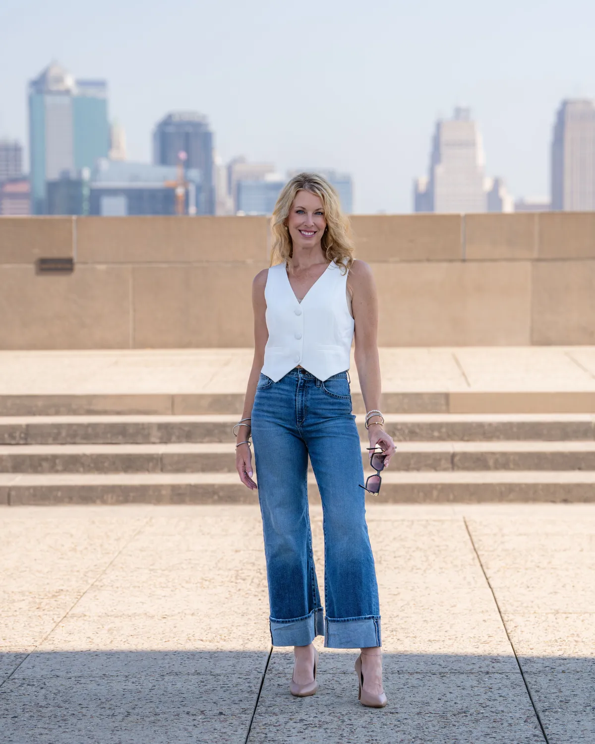 Cara Painter standing at Liberty Memorial with the Kansas City skyline behind her